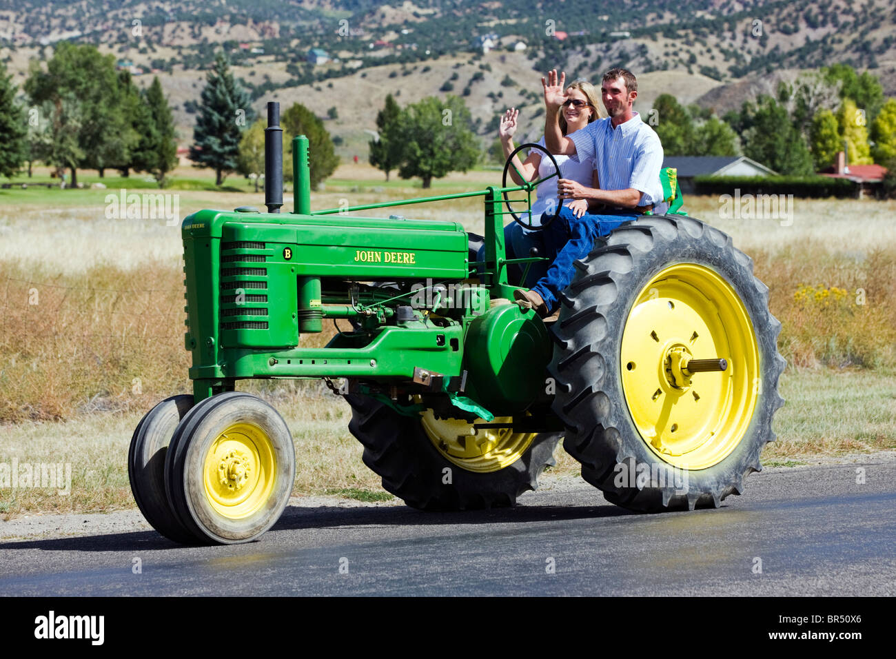 Newlywed couple marié à cheval sur un tracteur dans leur cortège nuptial de l'église à la réception, Salida, Colorado Banque D'Images