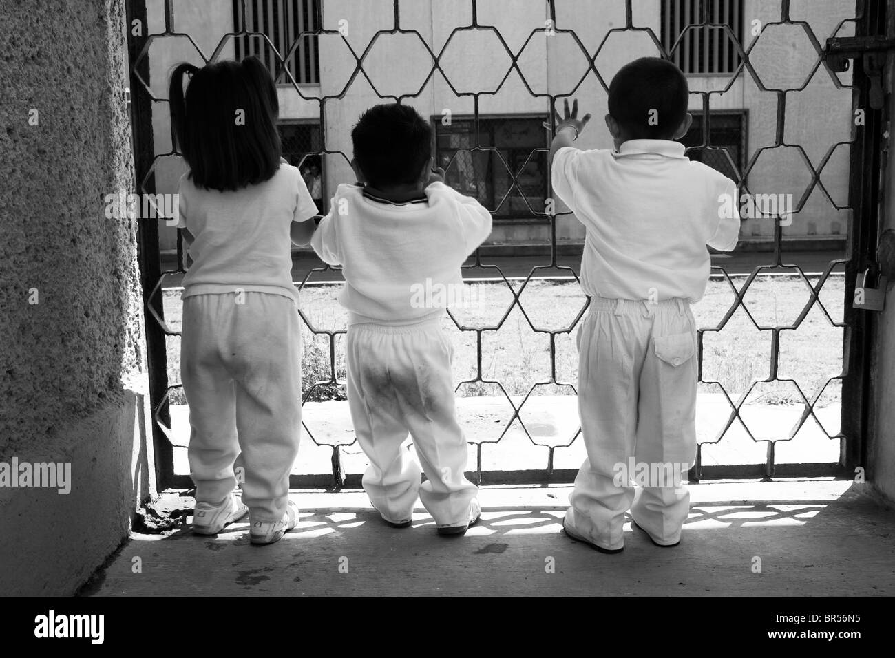 Enfants de chercher à travers les barreaux d'une prison à Mexico D.F. Banque D'Images