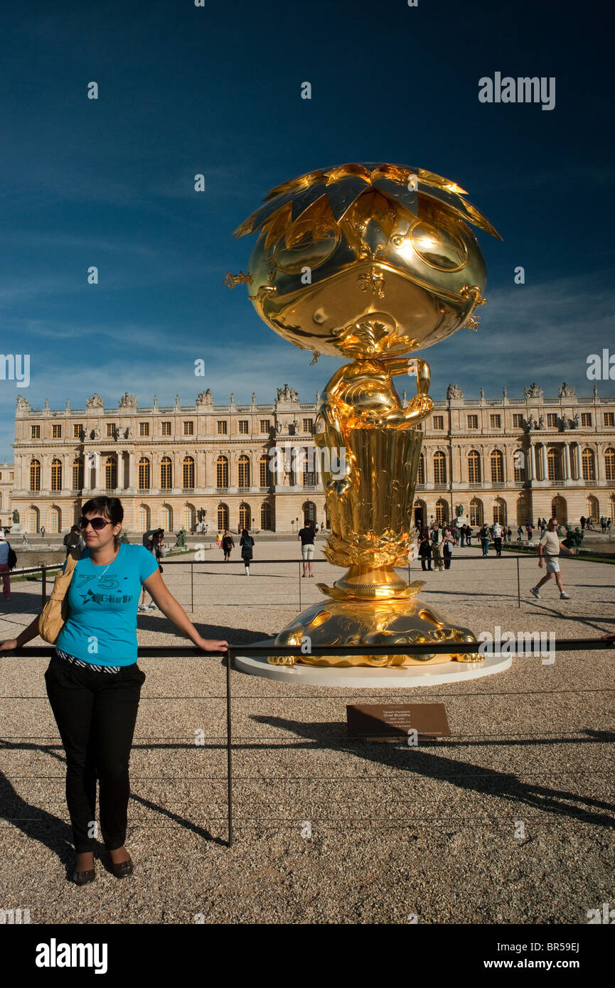 Woman in Garden, Versailles, France, touristes visitant le spectacle d'art contemporain, statue d'or « Bouddha ovale » « Takashi Murakami », haut musée d'art, château de Versailles France Banque D'Images
