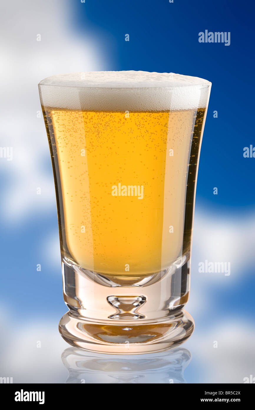 Petit verre de bière contre un fond de ciel bleu Banque D'Images