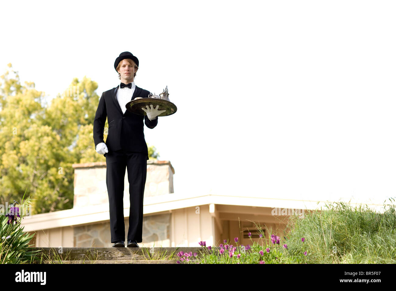 Man in tuxedo carrying tray Banque D'Images