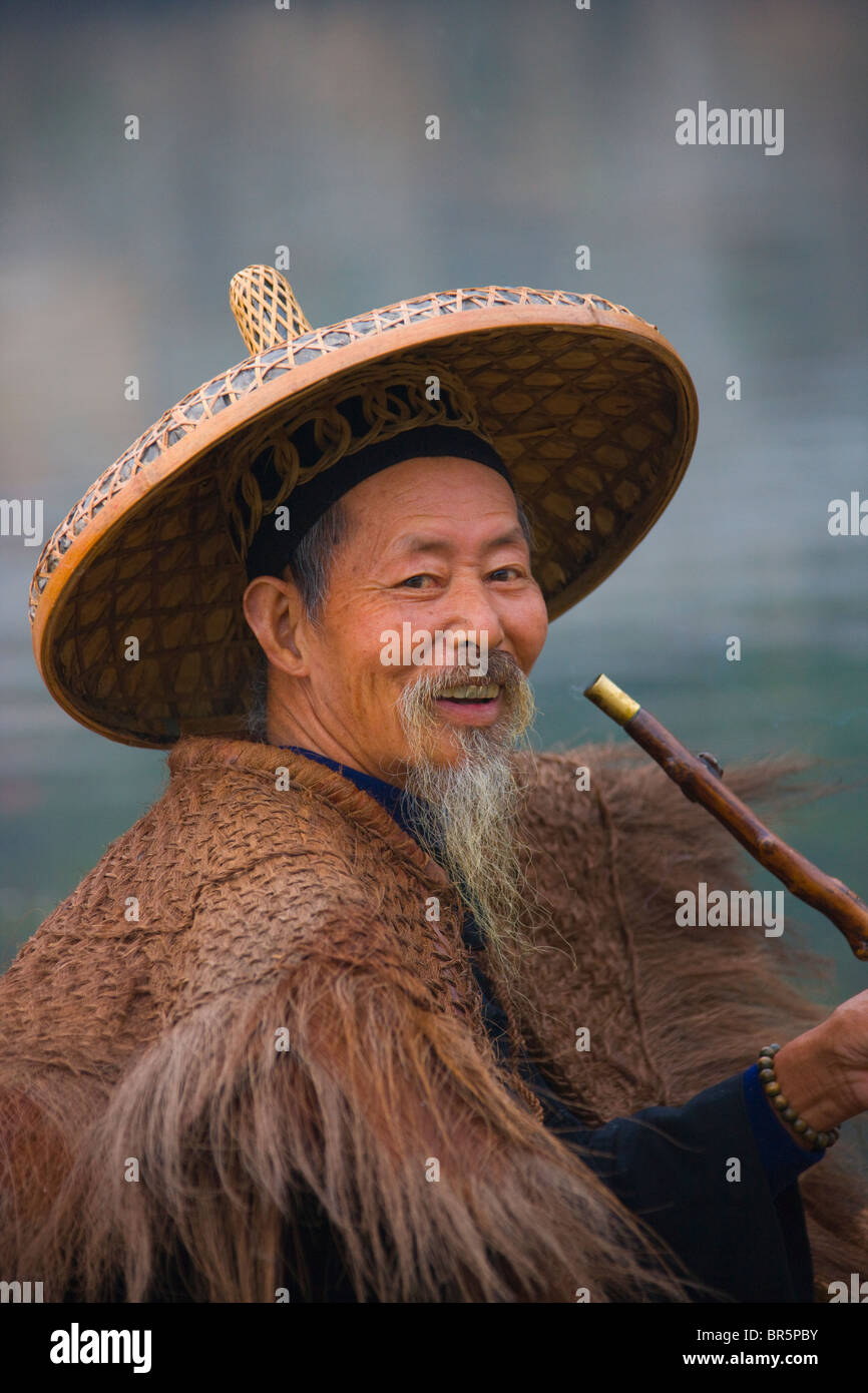 Fisherman in pipe manteau sur la rivière Li, Yangshuo, Guangxi, Chine Banque D'Images