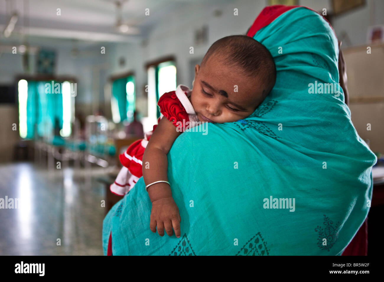 Une mère amène son bébé à l'enfant en besoin d'urgence de l'Institut. Led d'ONG les soins de santé. Banque D'Images