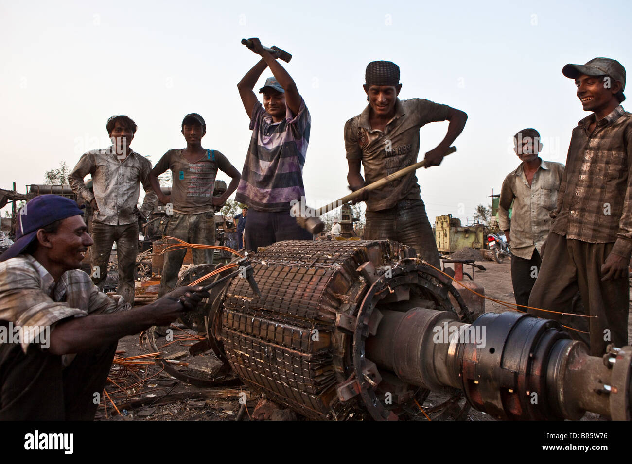 Un groupe d'hommes et de garçons adolescents briser un squelette pour récupérer le cuivre. Rupture Marine casse juste à l'extérieur de Bhavnagar. Banque D'Images