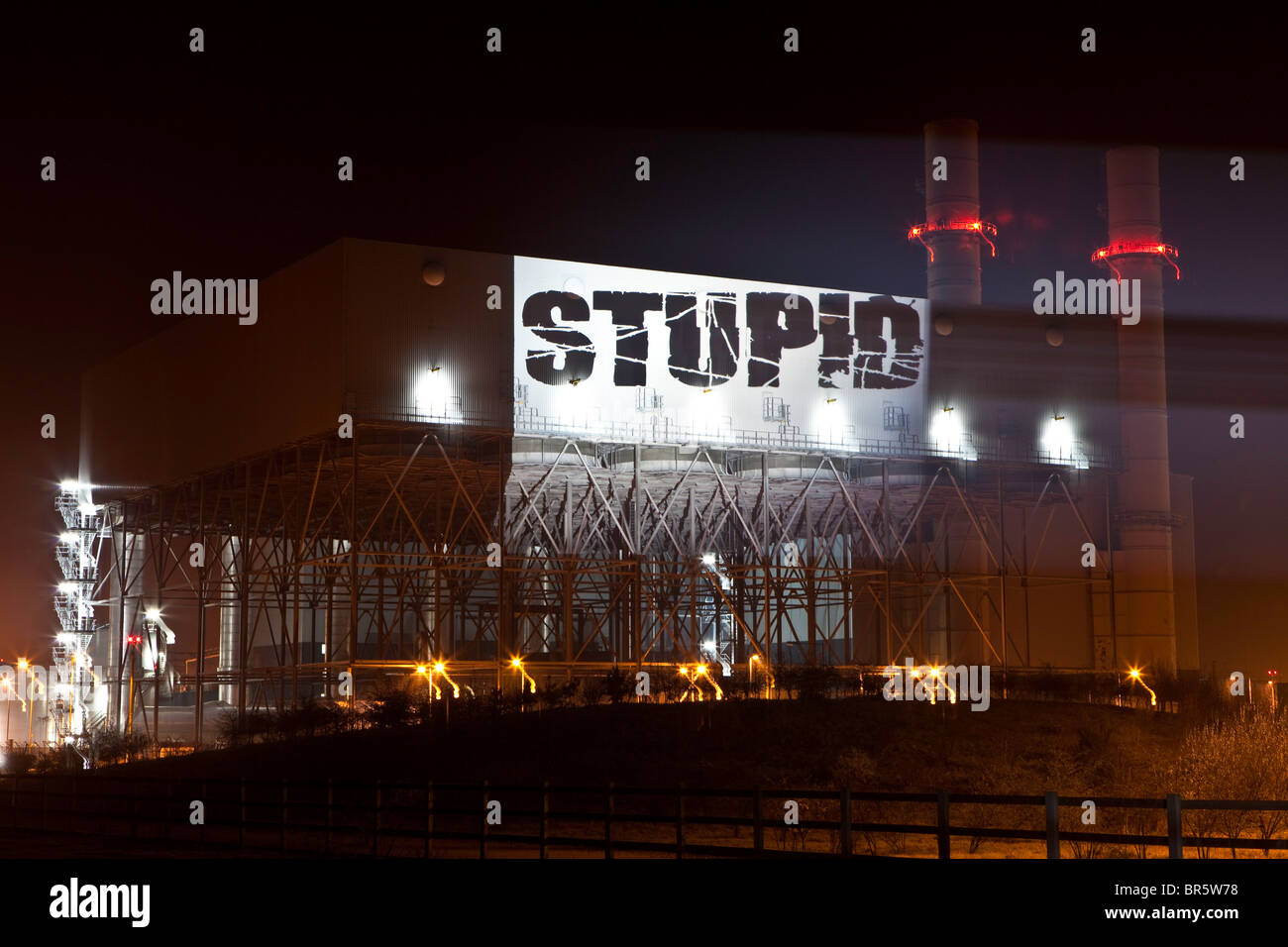 Le mot "stupide" est projeté sur le côté de Kingsnorth power station au cours d'une manifestation, Kent, UK. Banque D'Images