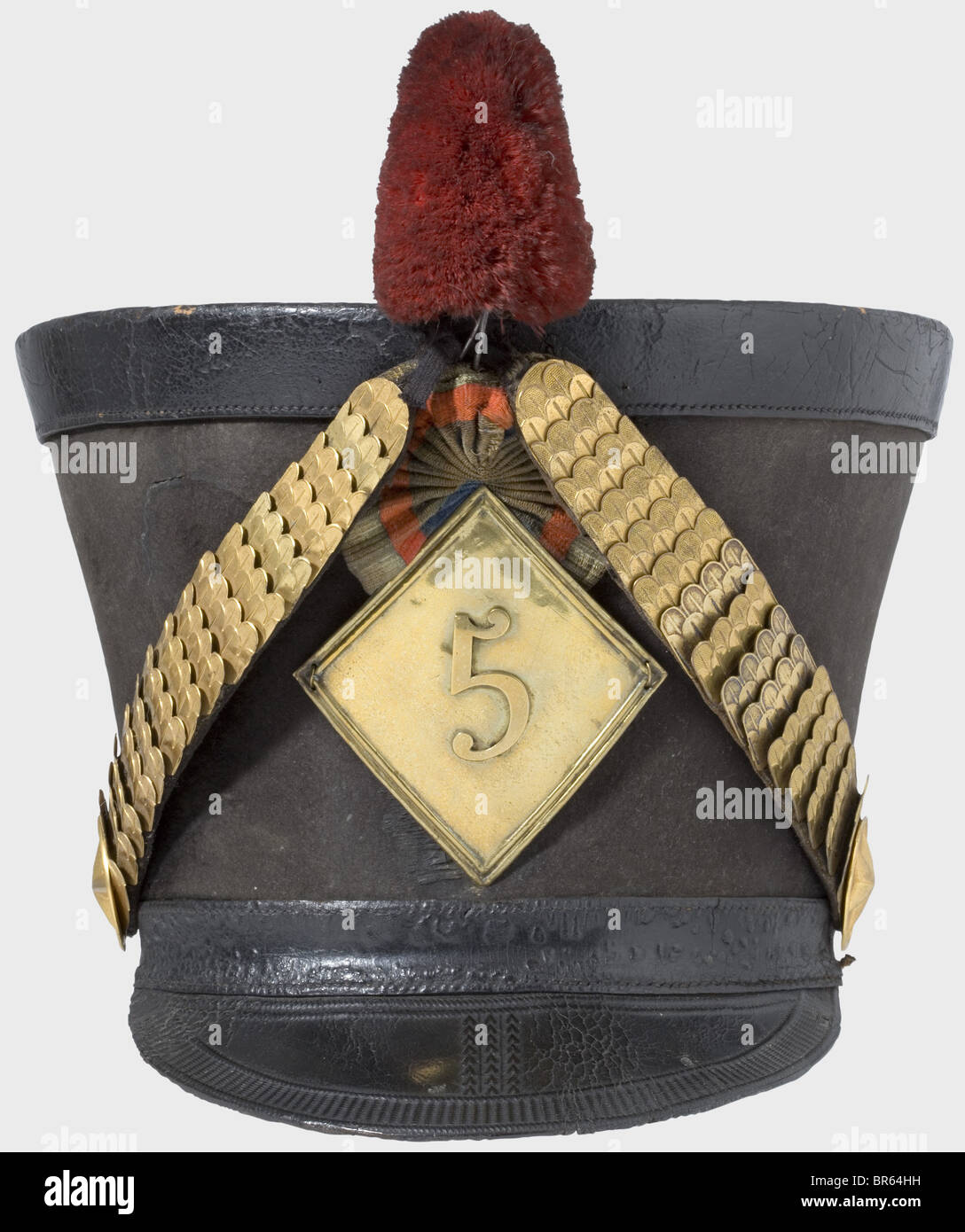 Un shako pour les officiers du 5ème Régiment Hussars, selon la réglementation de 1810. Grand corps en feutre noir (fissure en forme de croissant à l'avant). Serre-tête réglable et visière en cuir noir avec décoration à outils. Balances en laiton sur rosettes en étoile en relief. Emblème rhomboïdal en relief selon la réglementation de 1812 avec le numéro '5'. Cocarde et panache en cuir (pompon manquant). Bandeau en cuir et doublure en lin. Bande cuir et bande de sueur quelque peu court. Traces d'âge et d'utilisation. Le 5ème Régiment Hussars a combattu dans les batailles suivantes : Eylau, , Banque D'Images