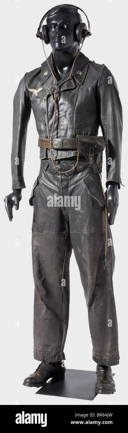 Un uniforme protecteur en cuir noir Luftwaffe panzer., une tunique en cuir noir lisse dans le modèle SS avec rabat à bouton couvert, boutons en plastique noir, un col portant des têtes de mort en métal et un aigle à poitrine brodé à la main. Panneaux d'épaule manquants. Sans doublure, avec seulement la poche intérieure et les ourlets de lin. Le timbre du fabricant est à peine détectable. Pantalon en cuir noir assorti avec doublure en coton gris. Les lacets réglables sur les jambes et la ceinture séparée sont manquants. Les deux vêtements ont évidemment été portés. Jeu très rare. Aussi une ceinture avec un bleu , Banque D'Images