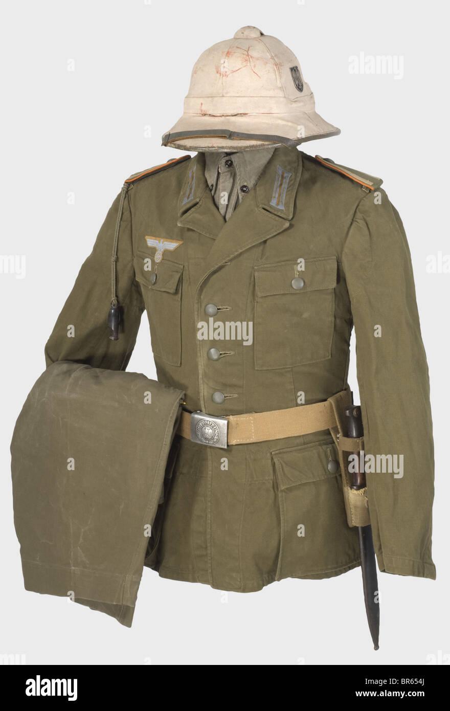 Un uniforme tropical pour une police militaire NCO., un casque solaire tropical peint en blanc avec insignes en métal, bordure en cuir gris et sangles de menton, et doublure rouge. Bandeau en cuir. Taille 57. Traces d'usure. Tunique en lin brun olive avec boutons gris de champ attachés par des anneaux, des timbres d'approvisionnement et de taille, un aigle de poitrine tissé sur un dos de couleur sable et des taches de col de couleur sable. Planches à bandoulière en boucle avec dentelle de couleur sable, bande à manches « Afrikakorps » tissée. Short du même matériau avec une ceinture tissée intégrée, et doublure blanche avec des timbres d'approvisionnement et de taille. Olive-b, Banque D'Images