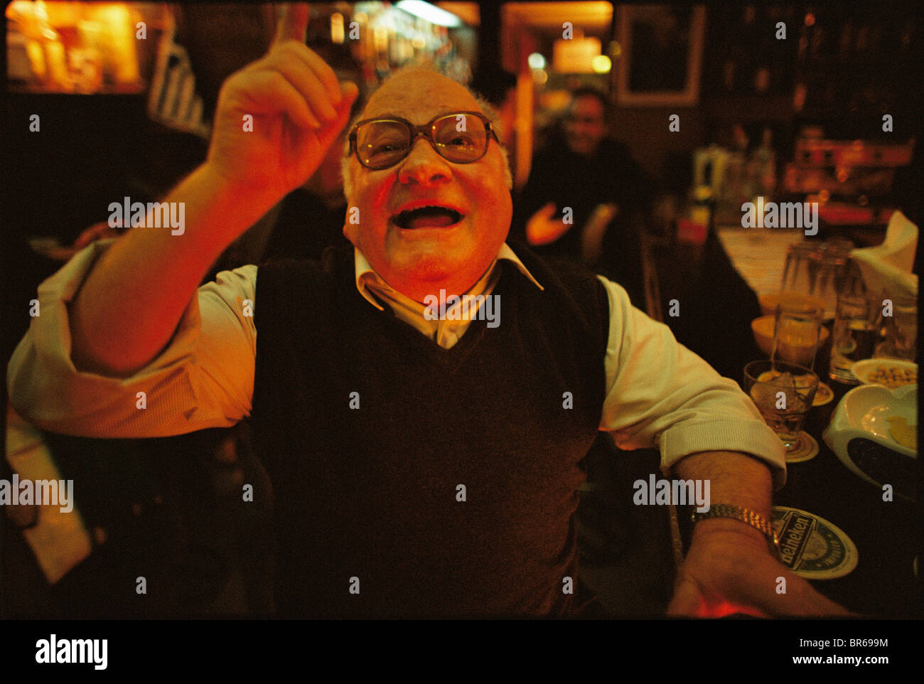 Un homme parlant et gesticulant dans un bar d'Athènes. Banque D'Images