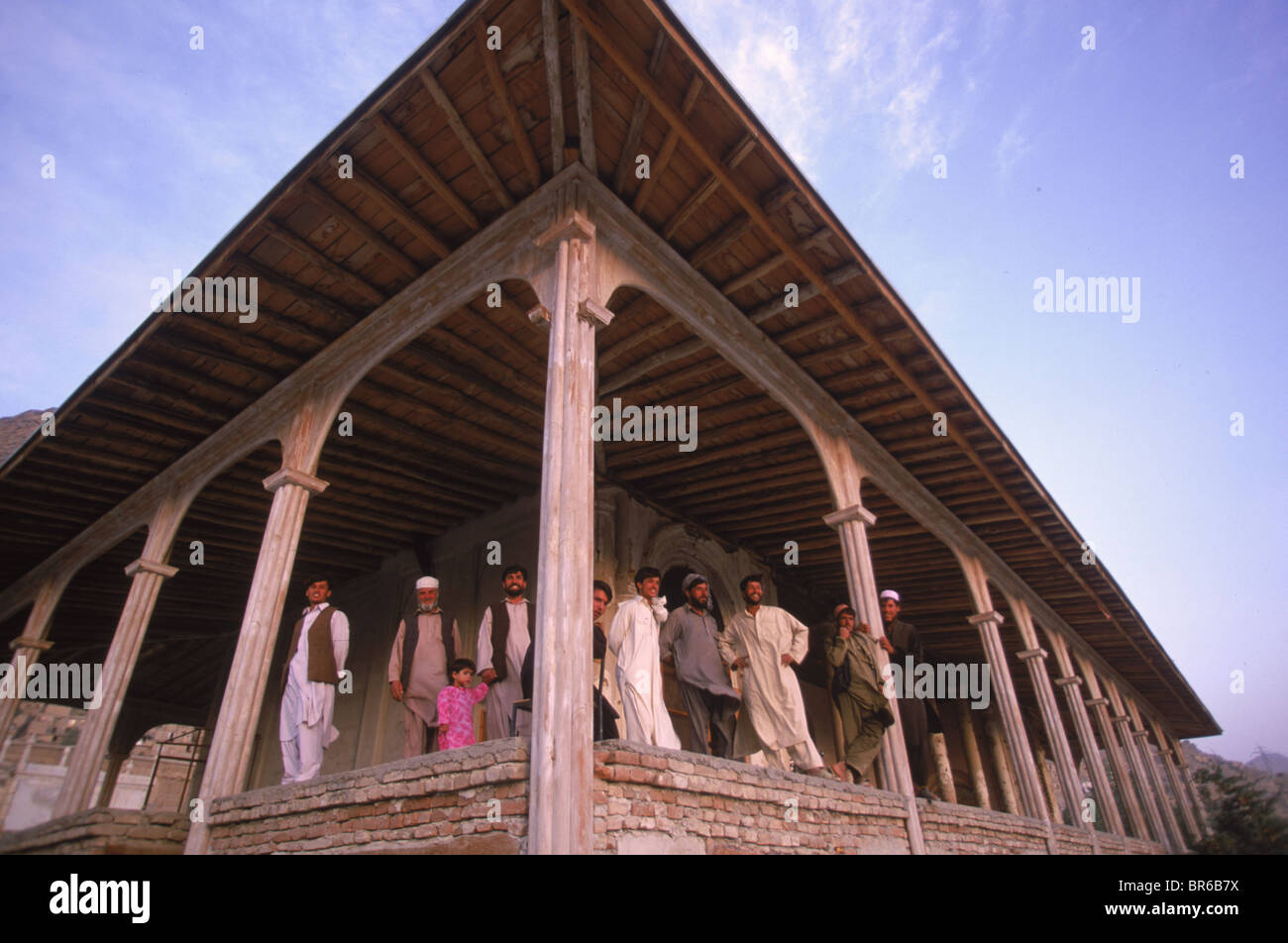 Pause des travailleurs par les colonnes d'un pavillon du 19ème siècle dans les jardins de Babour Kaboul Afghanistan Banque D'Images