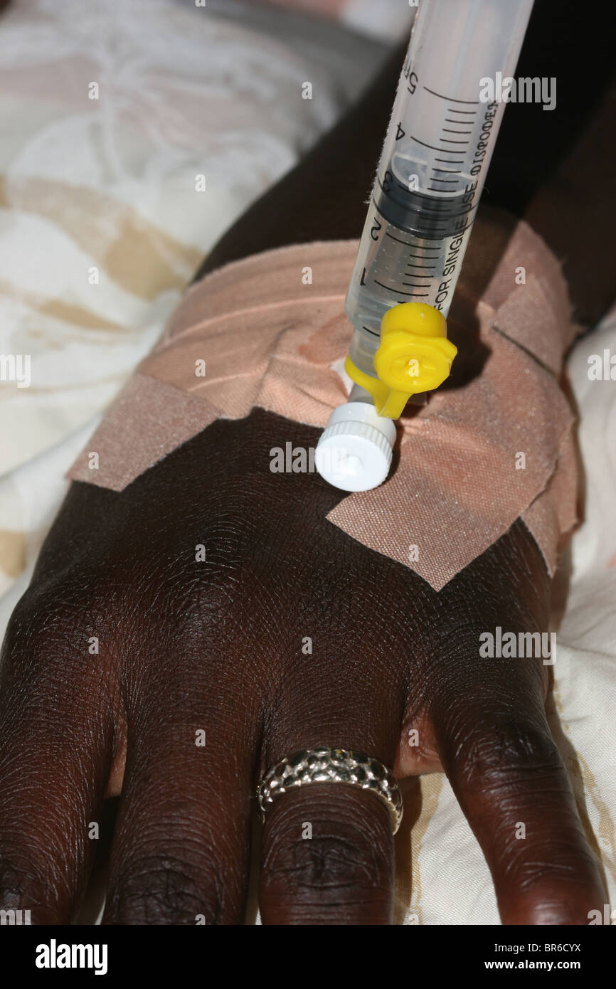 Une seringue attachée à la canule d'une main de femme pour perfusion de médecine Banque D'Images