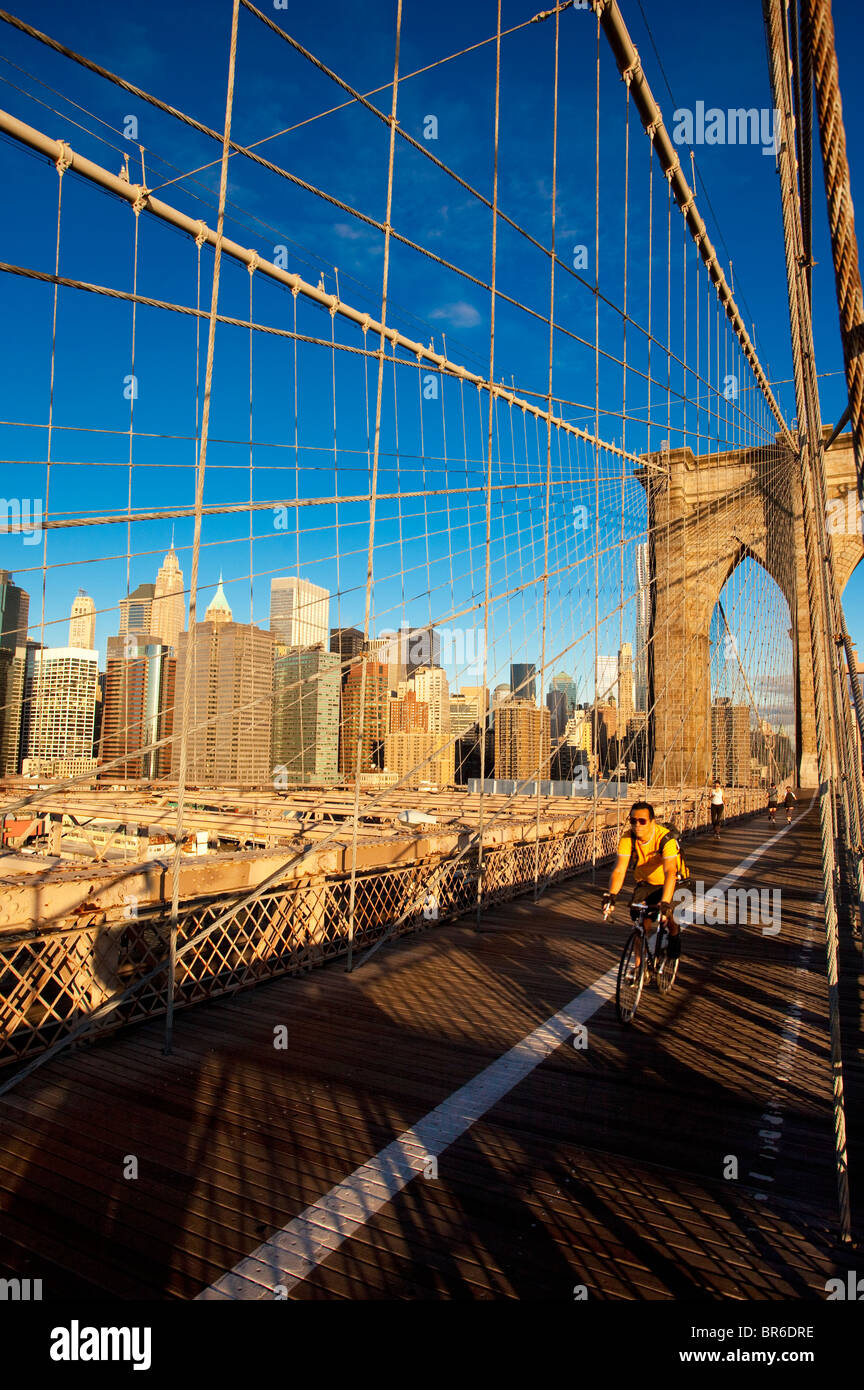 Cycliste et piétons traversant le pont de Brooklyn, Brooklyn et recouvrant la partie basse de Manhattan, New York City, USA Banque D'Images