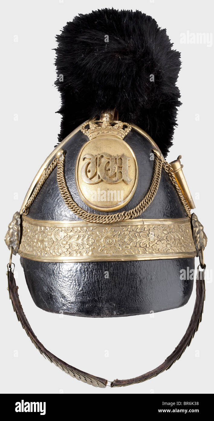 Casque pour officiers, de l'artillerie, vers 1840, presque identique au modèle bavarois 1832. Crâne en cuir avec barres de protection en laiton, chaînes défensives, et bande de rang avec décoration de feuilles en chêne en relief (petite fissure). Emblème ovale couronné portant un chiffrement superposé « W ». Écailles de chinelles de type officier sur les bossages de tête de lion, languette à boucle arrachée. Douille pour panache, doublure en cuir de mouton. La cocarde est manquante, l'écusson est remplacé par la fourrure noire, le pic avant est raccourci au moment de son utilisation. Casque rare. Historique, historique, XIXe siècle, Braunschweig, Brunswick, allemand, Banque D'Images