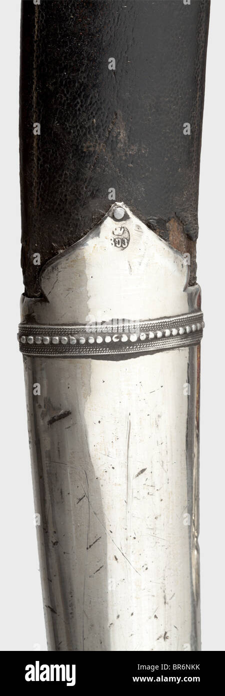 Un chamhir géorgien, Tiflis, daté de 1803. Lame à une seule lame de Damas forgée avec un point à double tranchant. Légèrement dénoyautés dans les endroits. Quillons de fer avec finals argentés à crénelée. Panneaux de poignée en corne sombre avec capuche de pommeau argenté. Barde en bois recouvert de cuir de shagren avec deux barres de suspension en fer. drape argentée épaisse avec marque d'inspection de Tiflis, datée de « 1803 » et marque de maître « AT ». Chaîne de suspension jaune-rouge fixée avec support final argent. Longueur 94 cm. Historique, historique, XIXe siècle, Empire ottoman, throuing, throulages, lame, lames, arme de mêlée, m, Banque D'Images