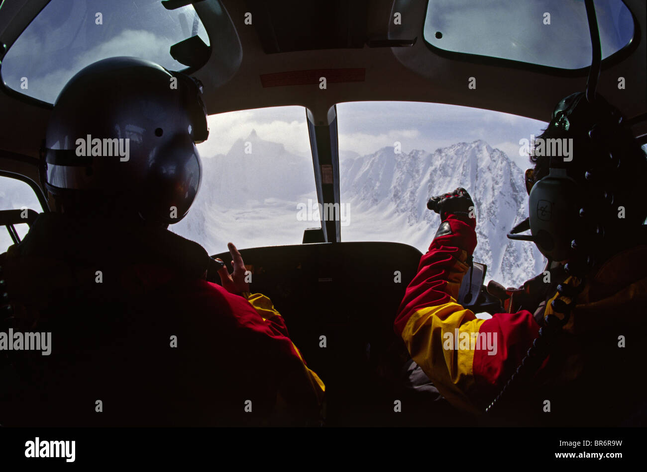 Avis de projet pilote et guide à la recherche d'une approche d'hélicoptère heli ski ski tandis que l'Alaska Banque D'Images
