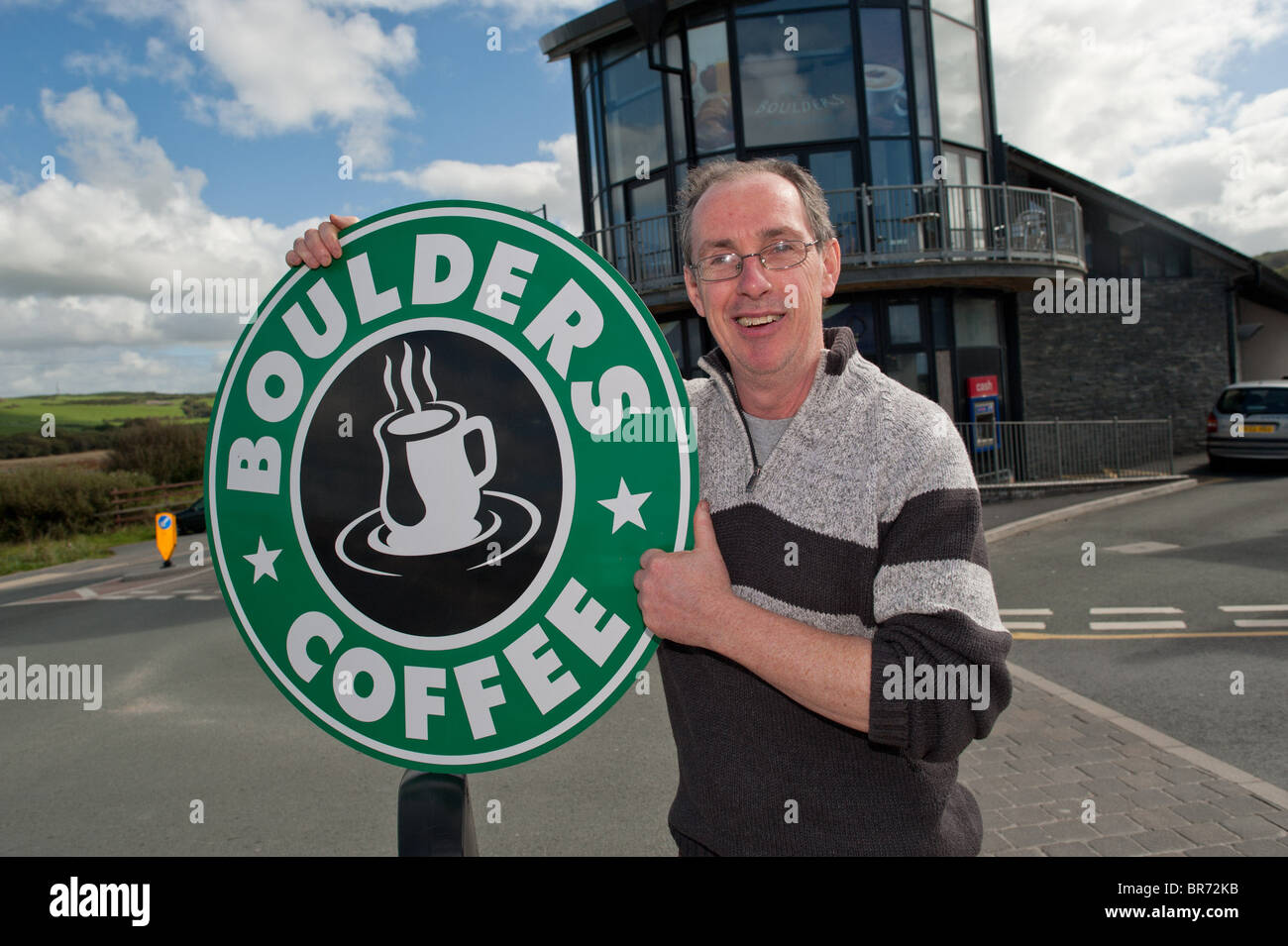 DEREK EDWARDS, le propriétaire de rochers Cafe , Borth, Pays de Galles au Royaume-Uni, avec le signe de son café qu'il a dû retirer Banque D'Images
