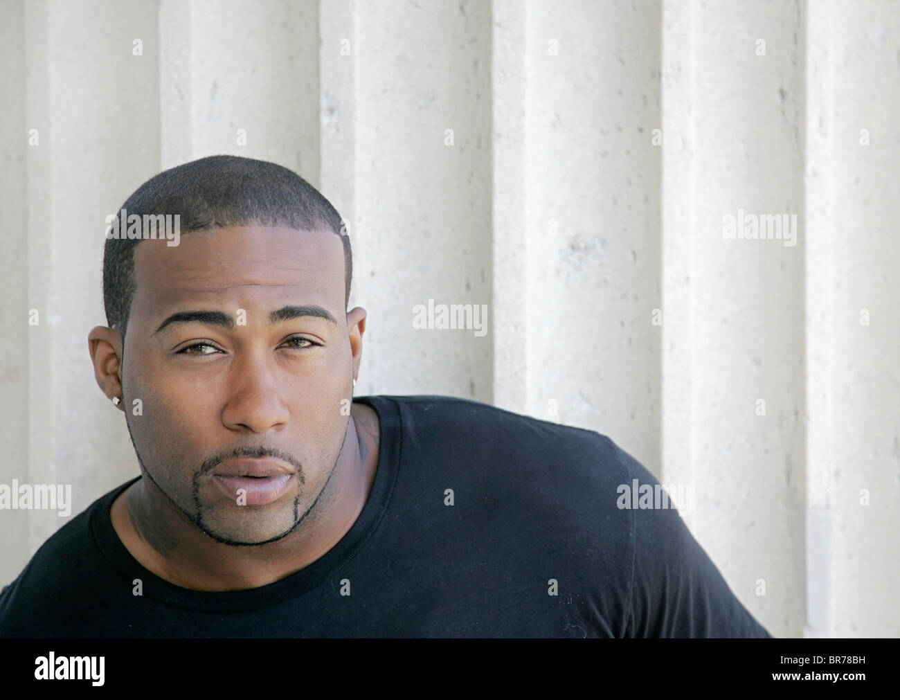 Young African American male portrait en face d'une colonne Banque D'Images