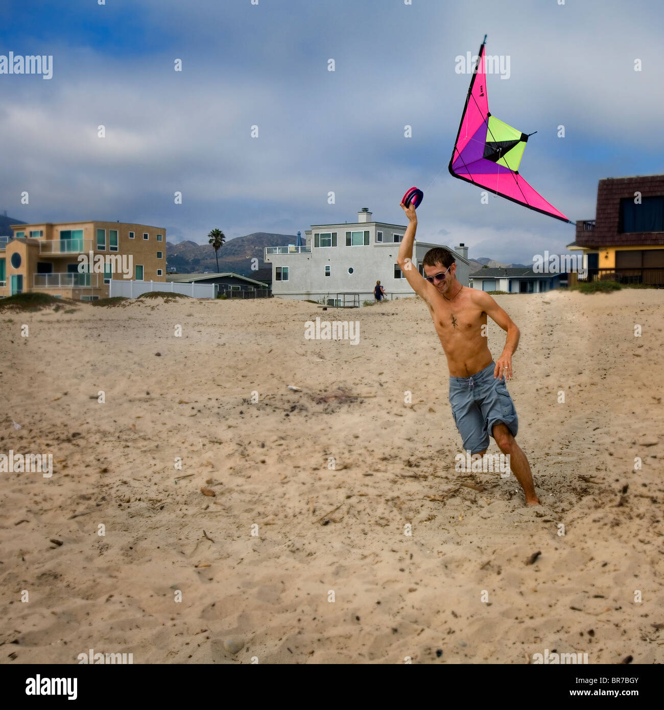 Jeune homme flying kite on beach Banque D'Images