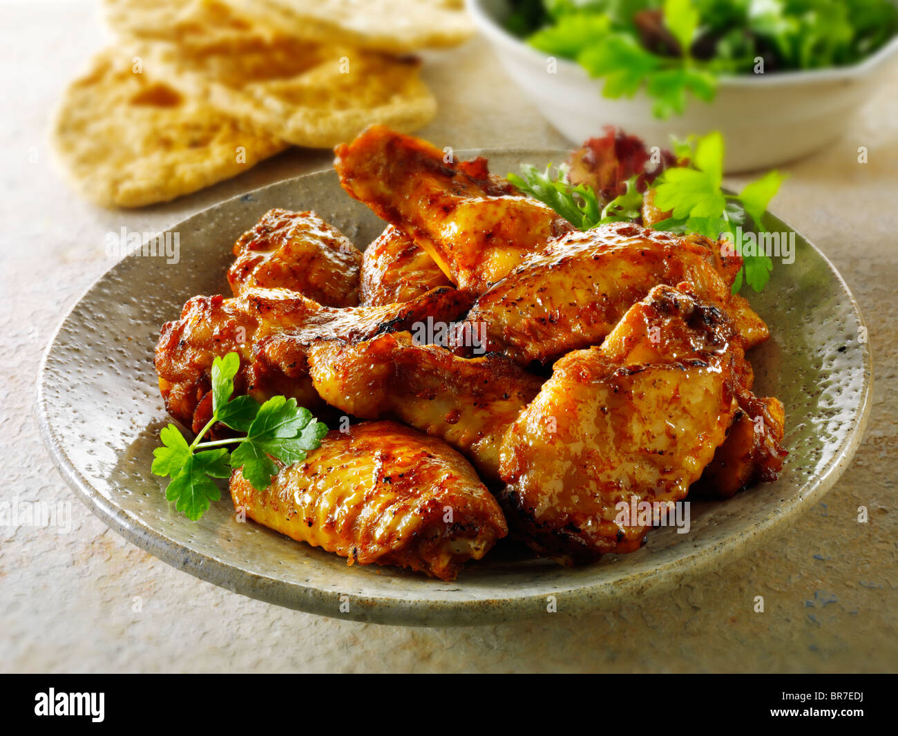 Barbecue (barbecue) ailes de poulet servies sur une assiette dans un cadre de table Banque D'Images