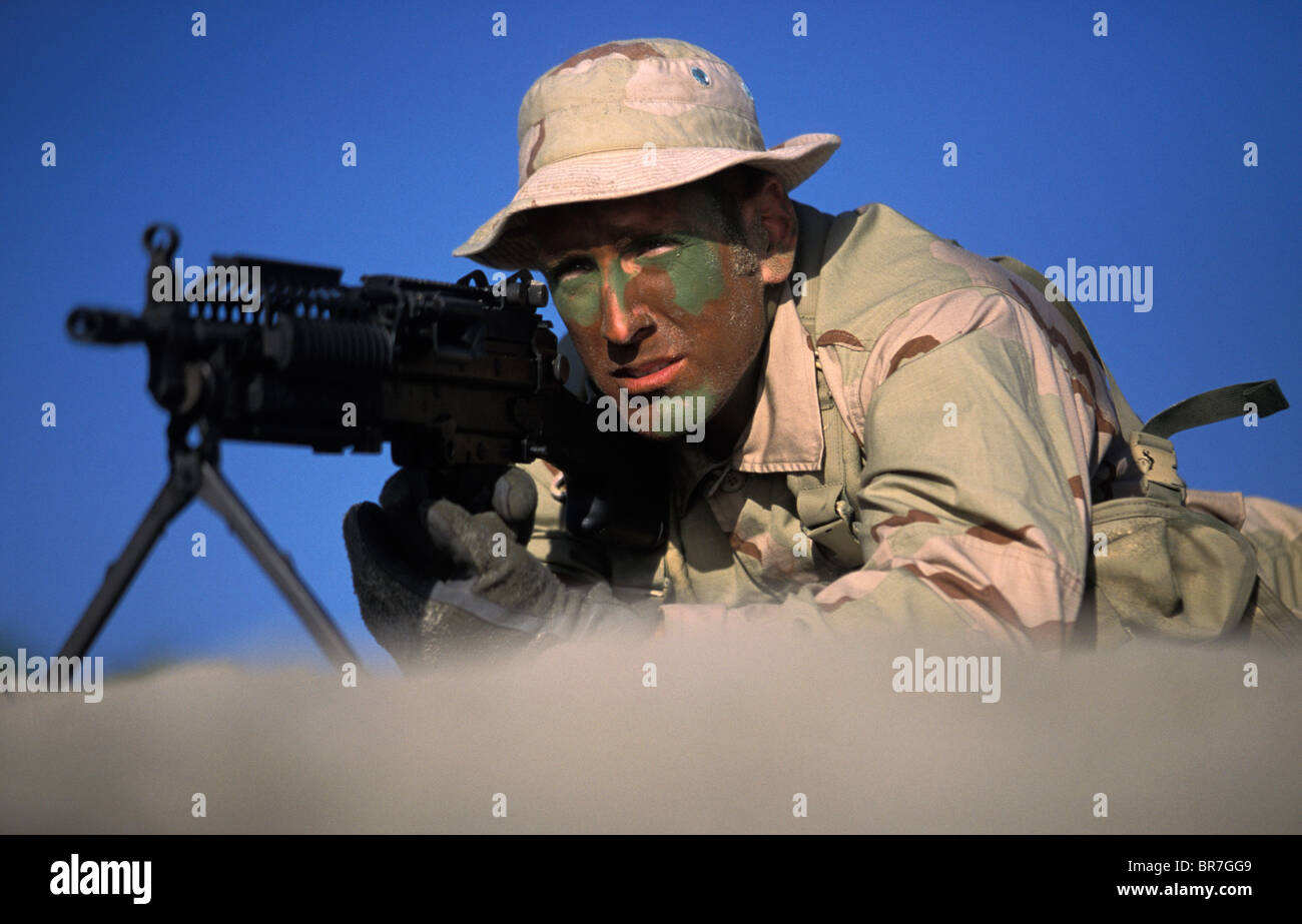 Navy Seal dans la formation portant sur la plage visant une arme à feu à San Diego en Californie. Banque D'Images