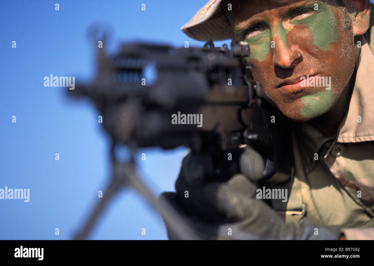 Navy Seal dans la formation portant sur la plage visant une arme à feu à San Diego en Californie. Banque D'Images
