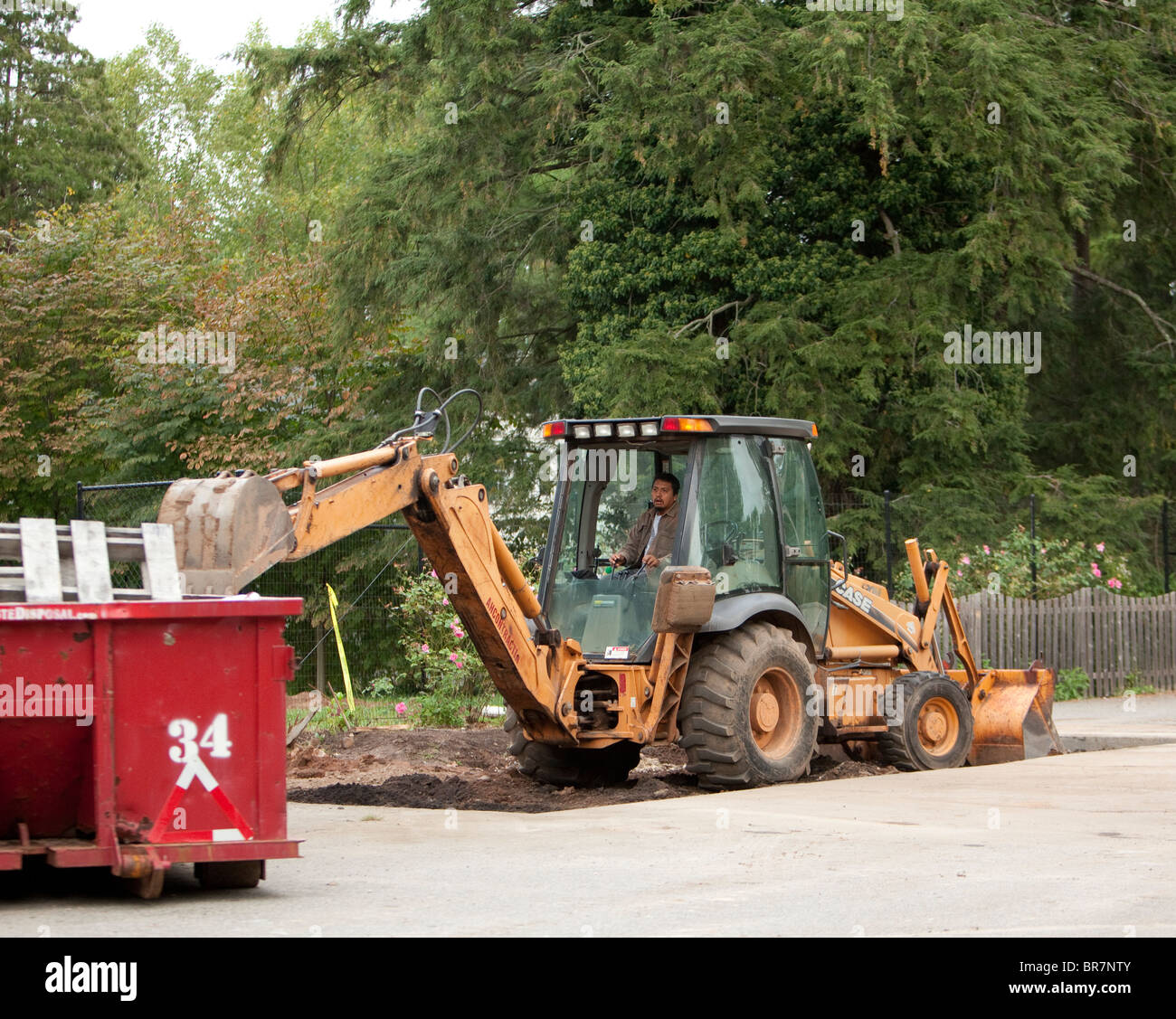 Un étui jaune tracteur avec chargeur frontal et rétro dans une fosse. Banque D'Images