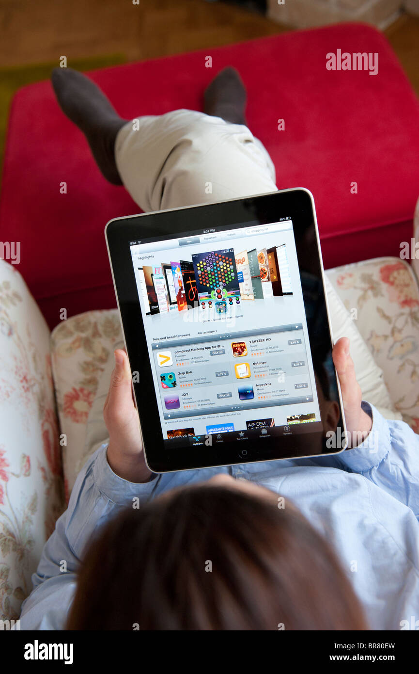 Femme à l'aide de l'ordinateur tablette iPad pour parcourir les applications dans l'App store d'Apple Banque D'Images