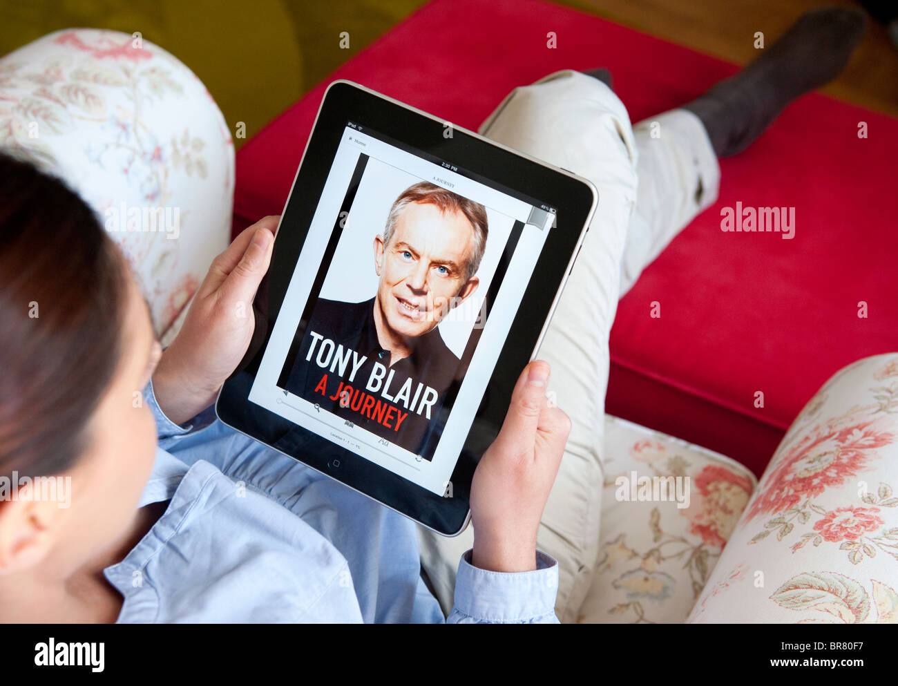 Femme à l'aide de l'ordinateur tablette iPad pour lire l'autobiographie de Tony Blair sur le ebook Banque D'Images