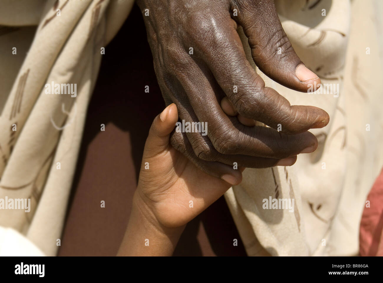 Un enfant tient la main de sa mère dans les files d'attente pour l'alimentation à un camp de personnes déplacées, la Somalie. Banque D'Images