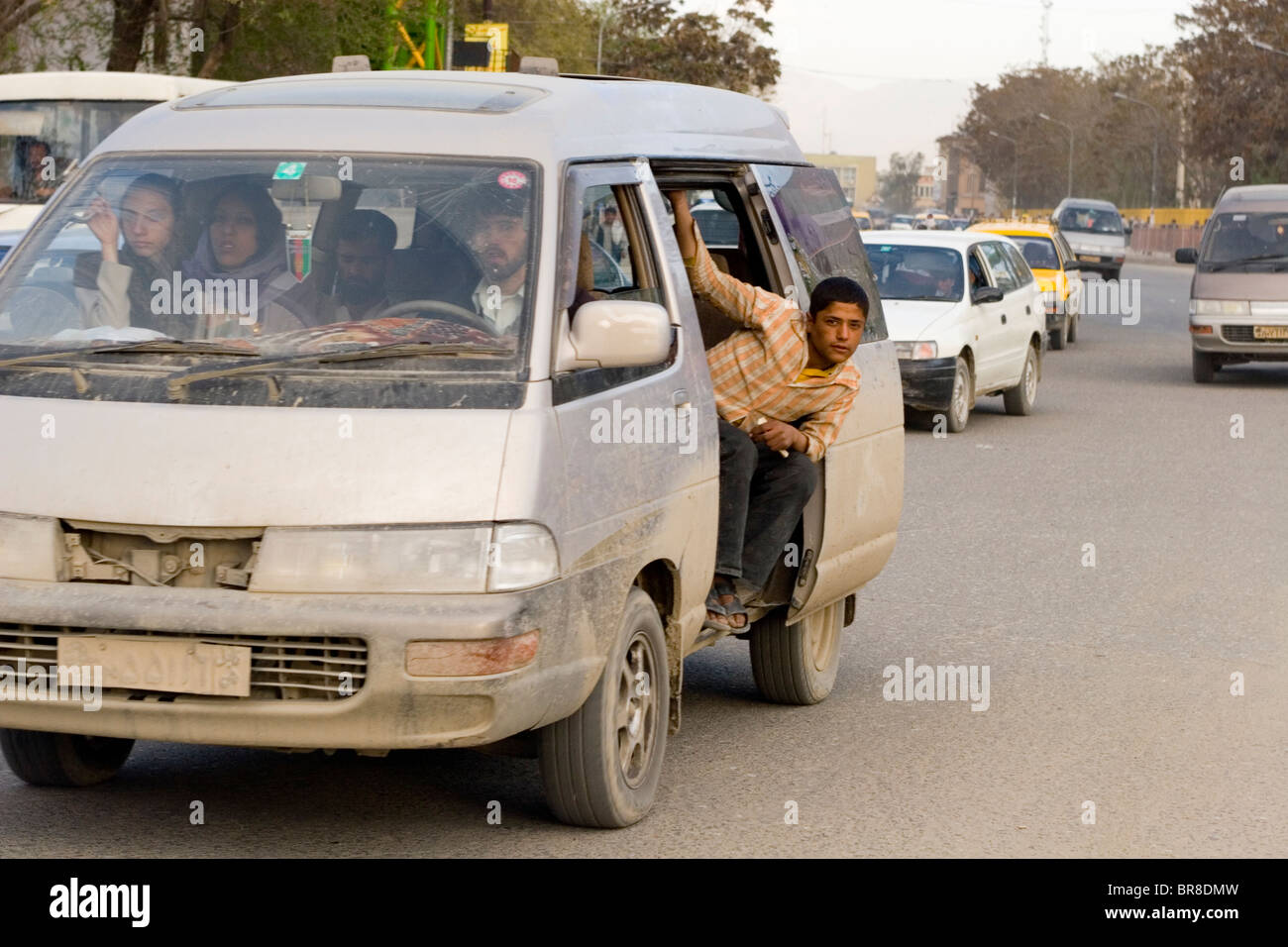 Un jeune homme sort la fenêtre ouverte d'un van bondé en heure de pointe à  Kaboul Photo Stock - Alamy