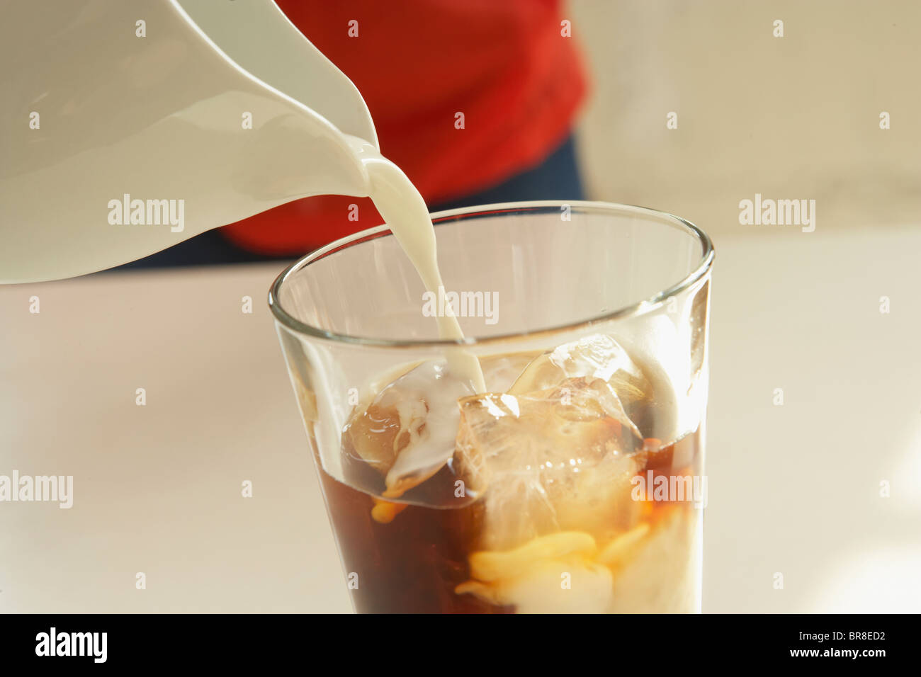 Verser le lait dans un verre de café glacé, Close up Banque D'Images