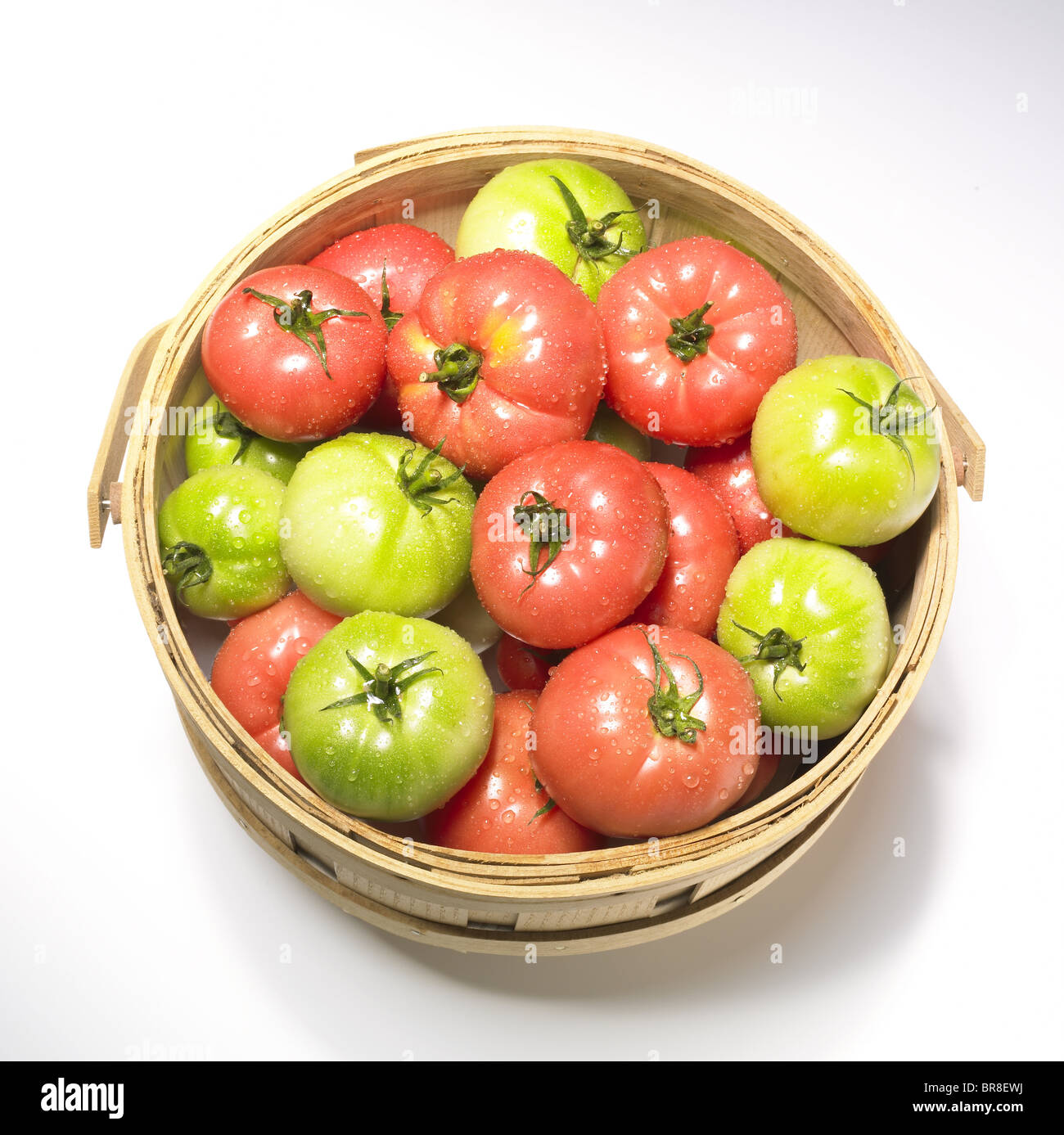 Les tomates rouges et verts dans le panier, fond blanc Banque D'Images