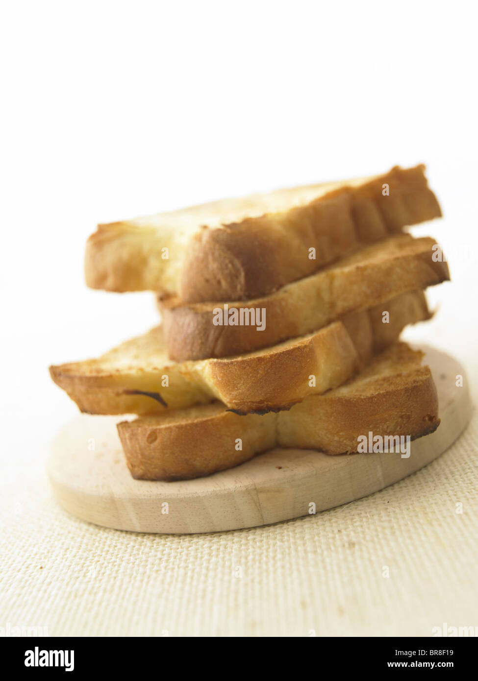 Tas de pain grillé sur une planche à découper, Close up, fond blanc Banque D'Images