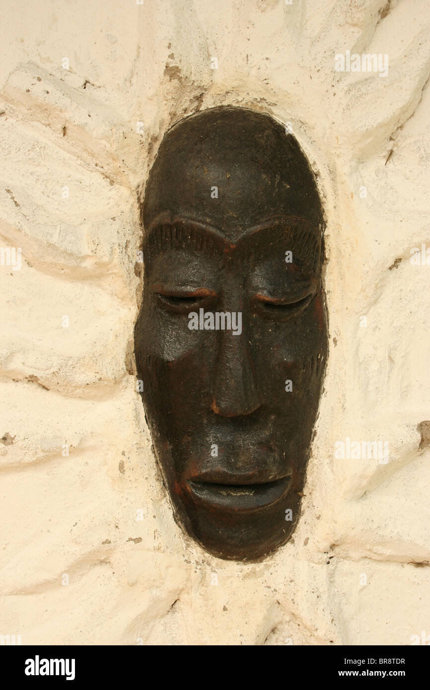 Un Africain masque traditionnel intégré dans un mur Banque D'Images