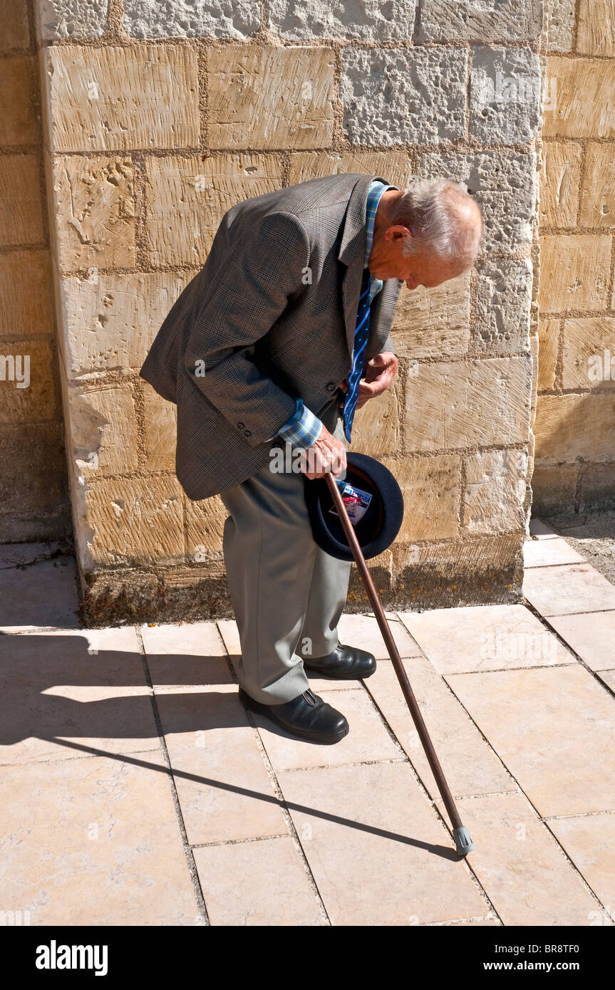 Vieille intuition-retour homme avec bâton de marche en appui sur trottoir - France. Banque D'Images