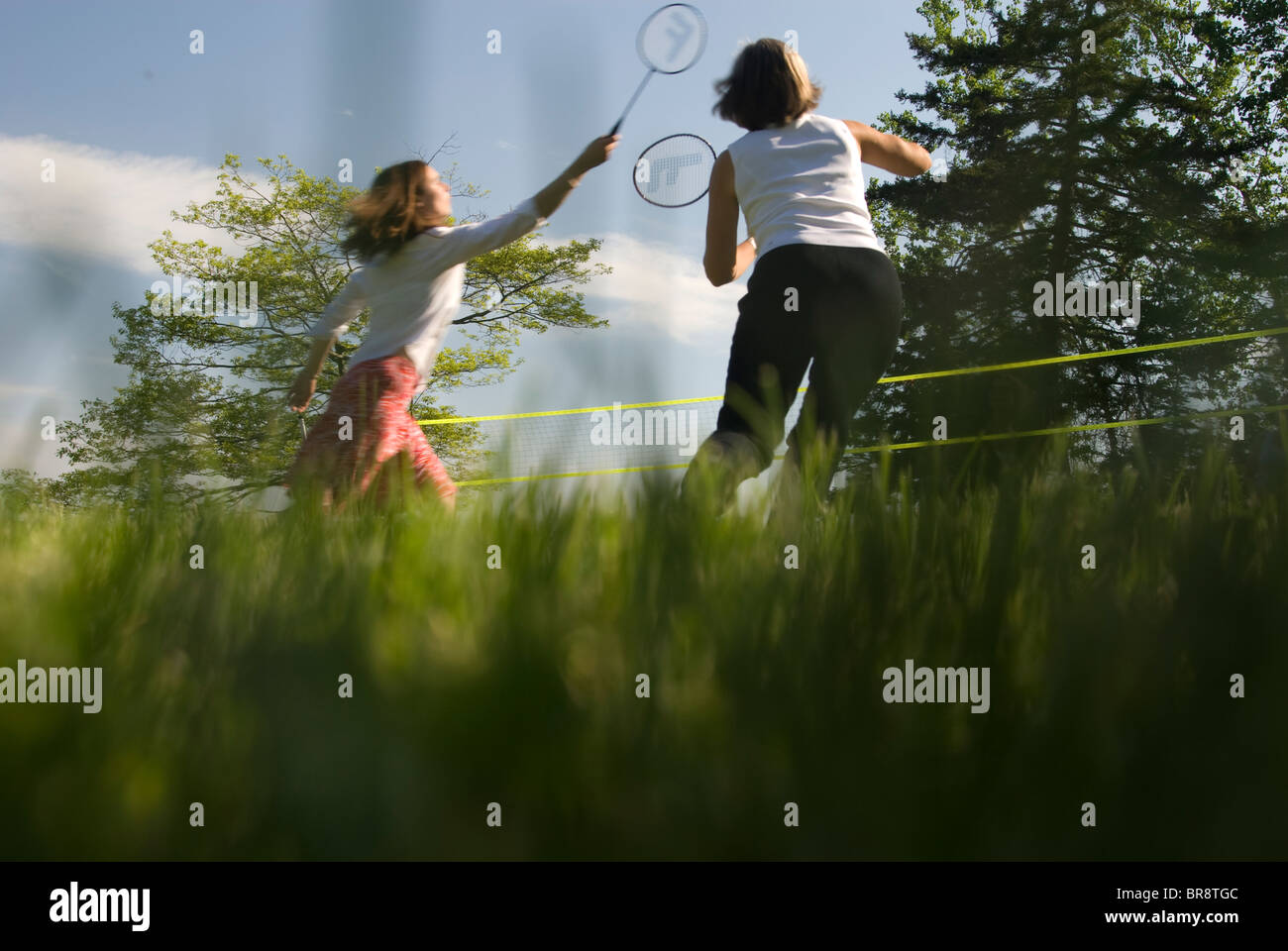 Deux femmes jouer au badminton sur une pelouse ensoleillée sur de simples Point près de Brunswick dans le Maine. Banque D'Images