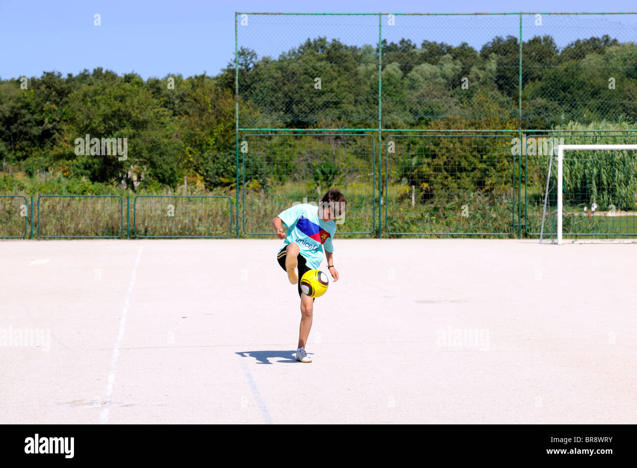 Teenage boy playing football / soccer Banque D'Images