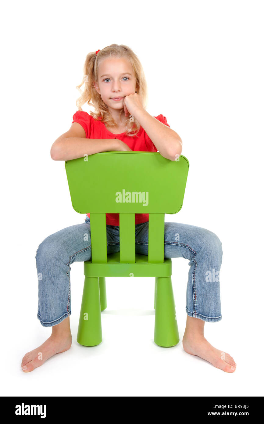 Jeune fille blonde sur fauteuil vert over white background Banque D'Images