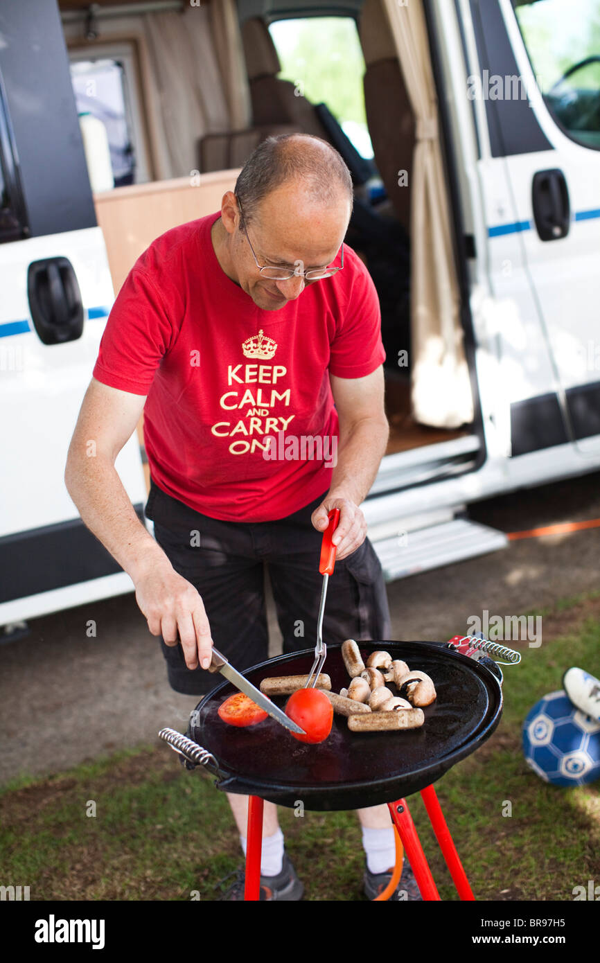 Petit-déjeuner de cuisson l'homme sur un réchaud portatif à l'extérieur de sa maison mobile, au Royaume-Uni. Banque D'Images