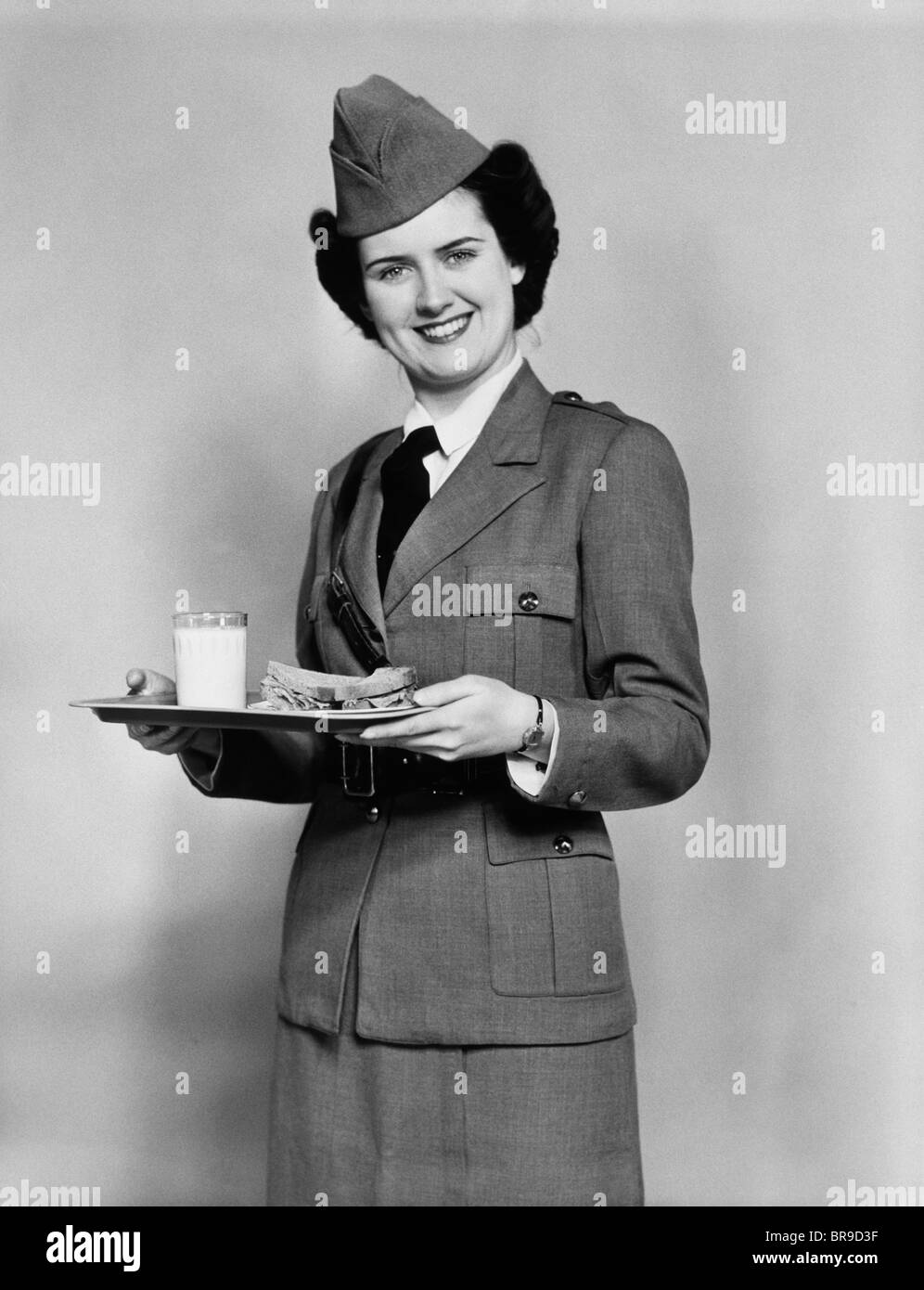 1940 Femme de l'ARMÉE AVEC DÉJEUNER PLATEAU AVEC UN VERRE DE LAIT ET DE SANDWICH Banque D'Images