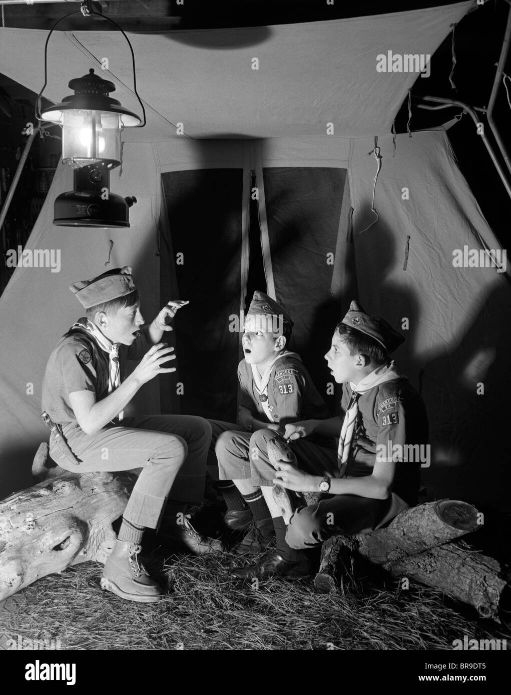 1960 3 SCOUTS ASSIS NUIT tente de dire les histoires de fantômes Banque D'Images