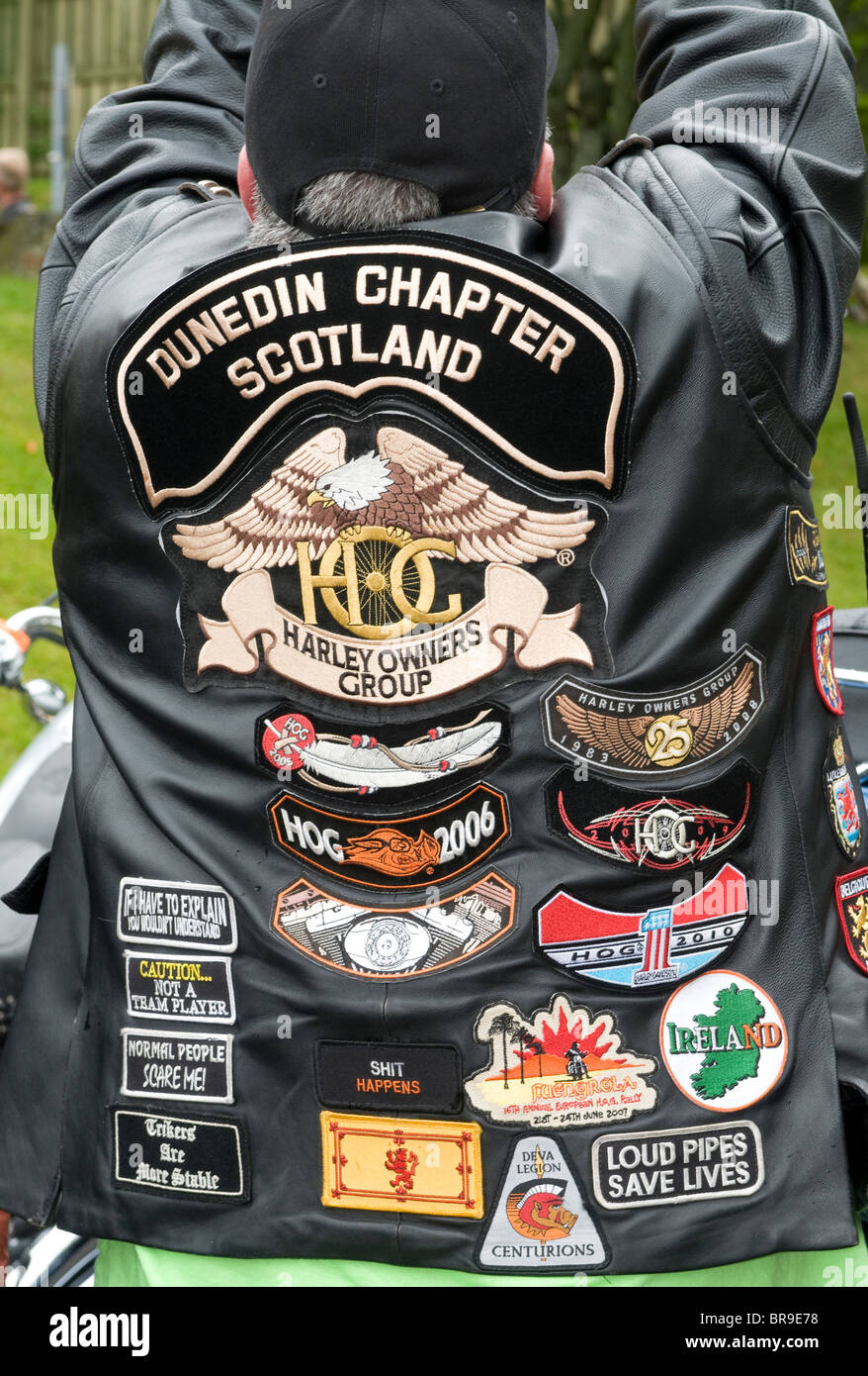 Fier propriétaire de vélo Harley Davidson Bikers, montre son blouson de cuir décoré d'insignes et logos 6656 SCO Banque D'Images