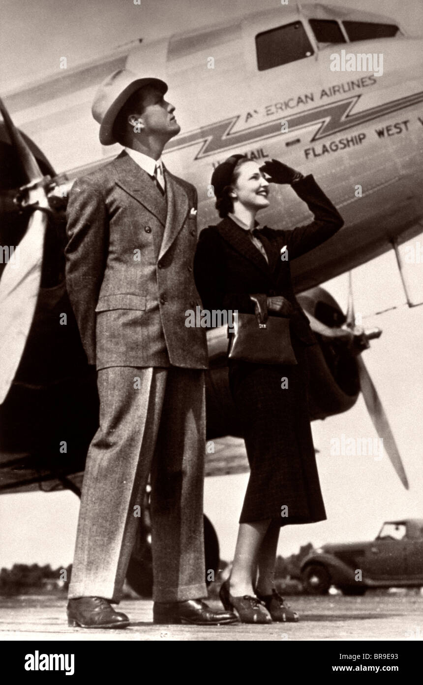 1930 COUPLE haut de gamme sur le tarmac à côté d'AVION Banque D'Images