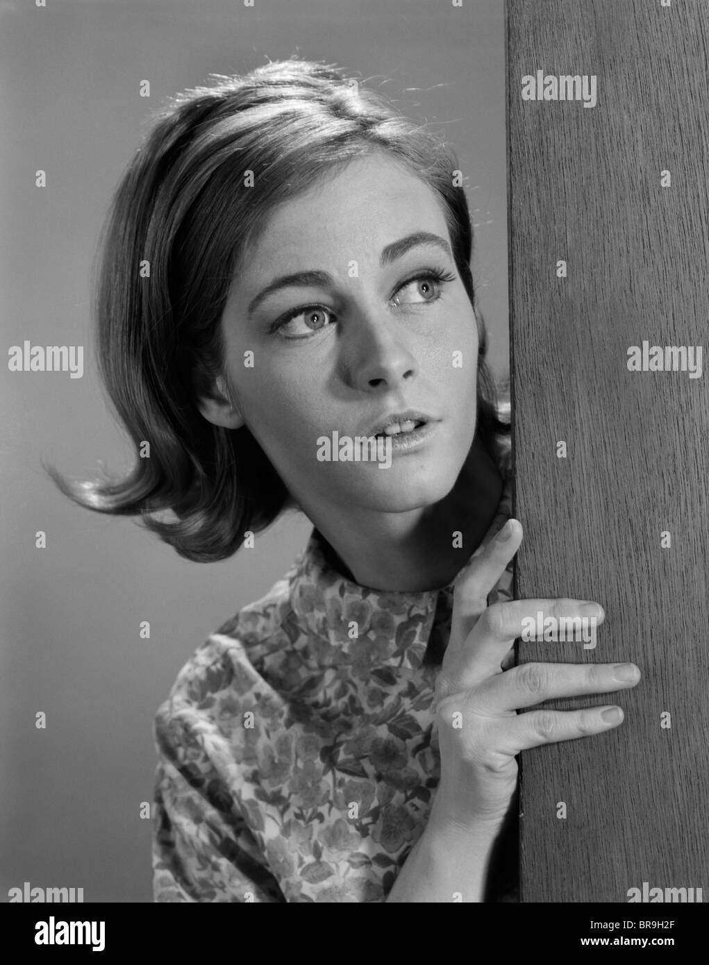 1960 WOMAN PEEKING CORNER SCARE Banque D'Images