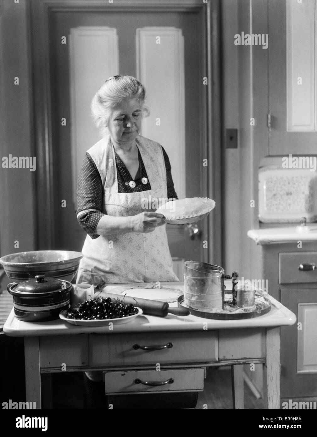 Années 1920 Années 1930 FEMME GRAND-MÈRE portant un tablier en croûte de sertissage CHERRY PIE Banque D'Images