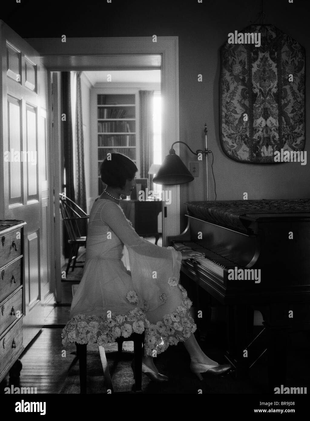 Années 1920, le pianiste FEMME ASSIS À JOUER DU PIANO Banque D'Images