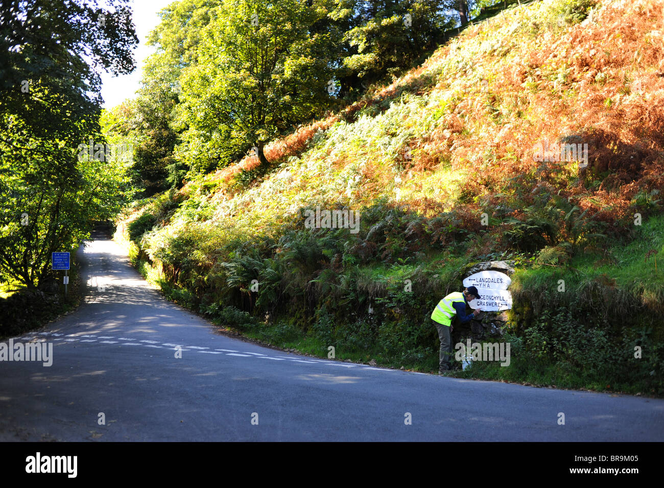 Man painting road sign à Loughrigg est tombé près de la Lake District village d'Ambleside Cumbria UK Banque D'Images