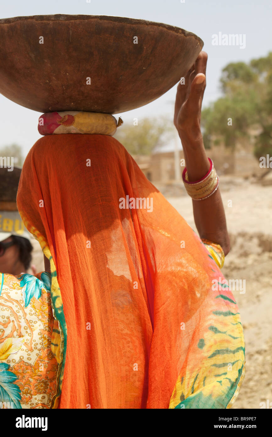 Rajasthan femme de l'arrière avec une assiette sur la tête Banque D'Images