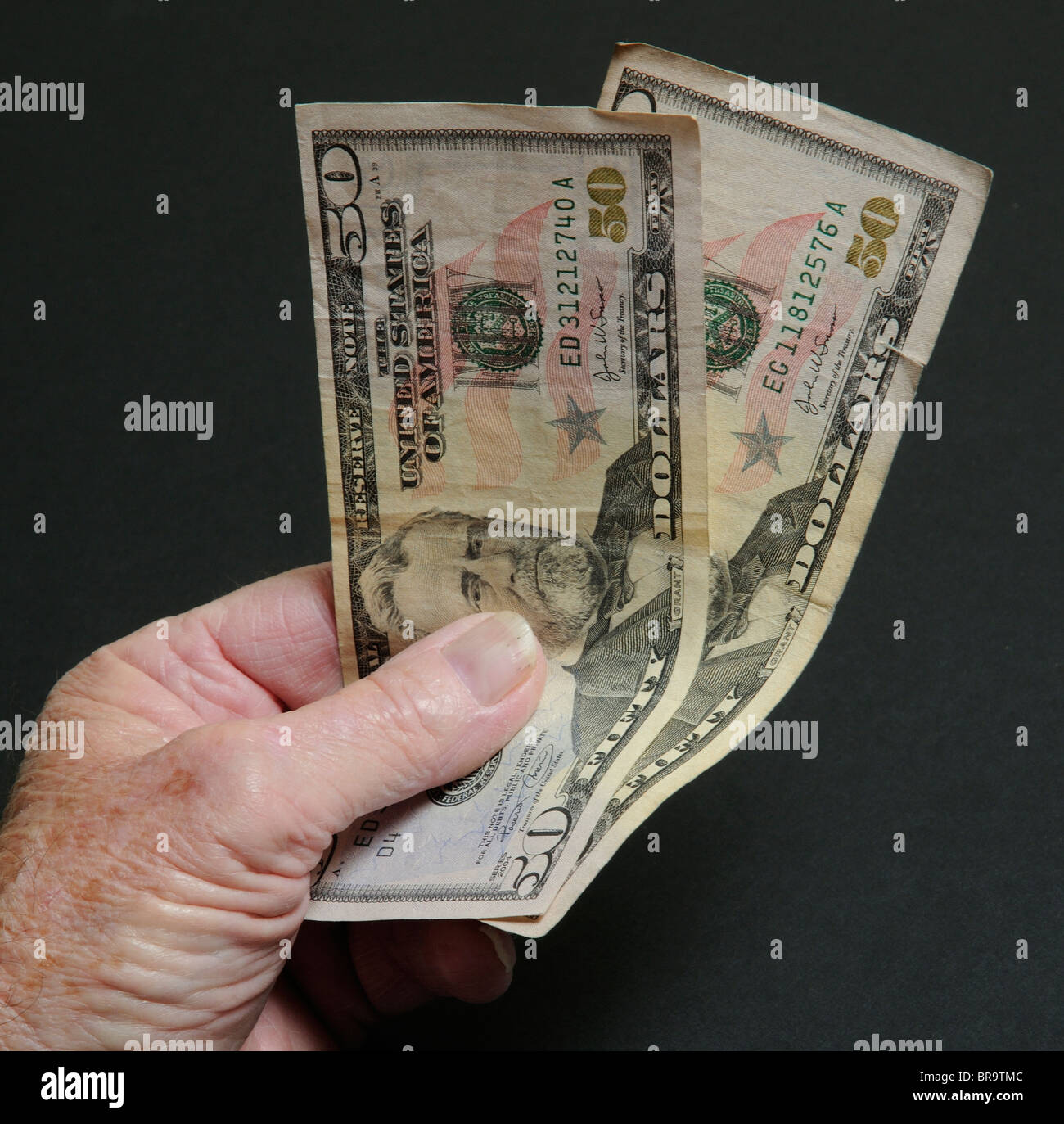 Poignée de Dollars US Federal Reserve $50 dollars dans la main d'un homme Banque D'Images