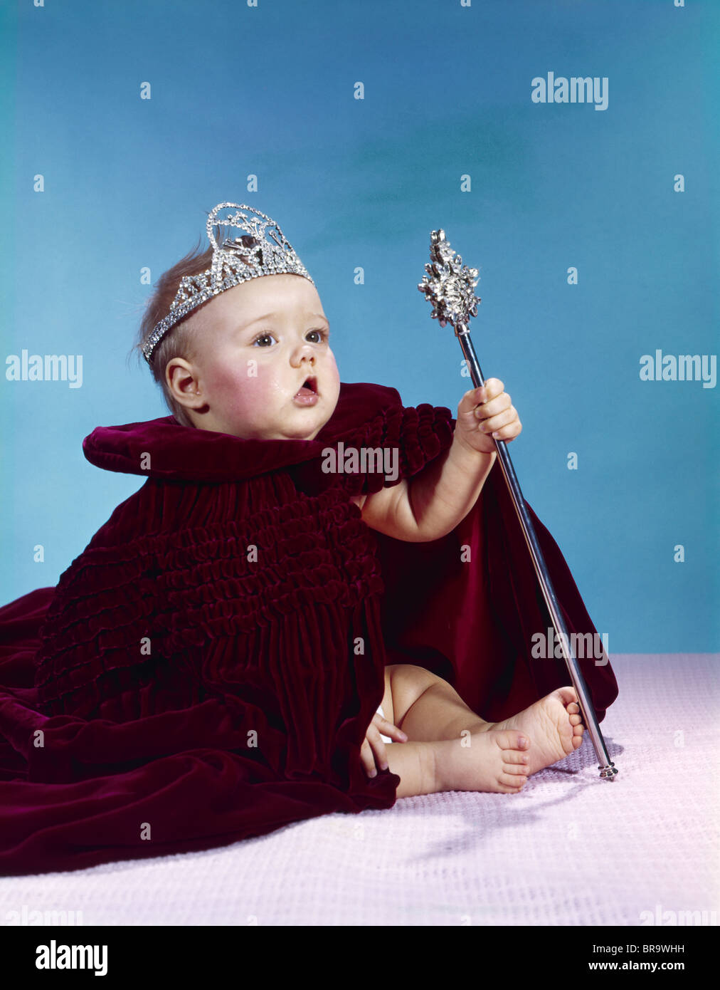 1960 BÉBÉ habillé comme ROYAL QUEEN DANS UNE ROBE DE VELOURS MANTEAU CAPE RHINESTONE TIARA COURONNE ET SCEPTRE WAND Banque D'Images